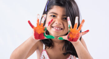 Happy Holi Greeting - Cute little Indian girl with colourful hands, isolated over white background Happy Holi Greeting - Cute little Indian girl with colourful hands, isolated over white background